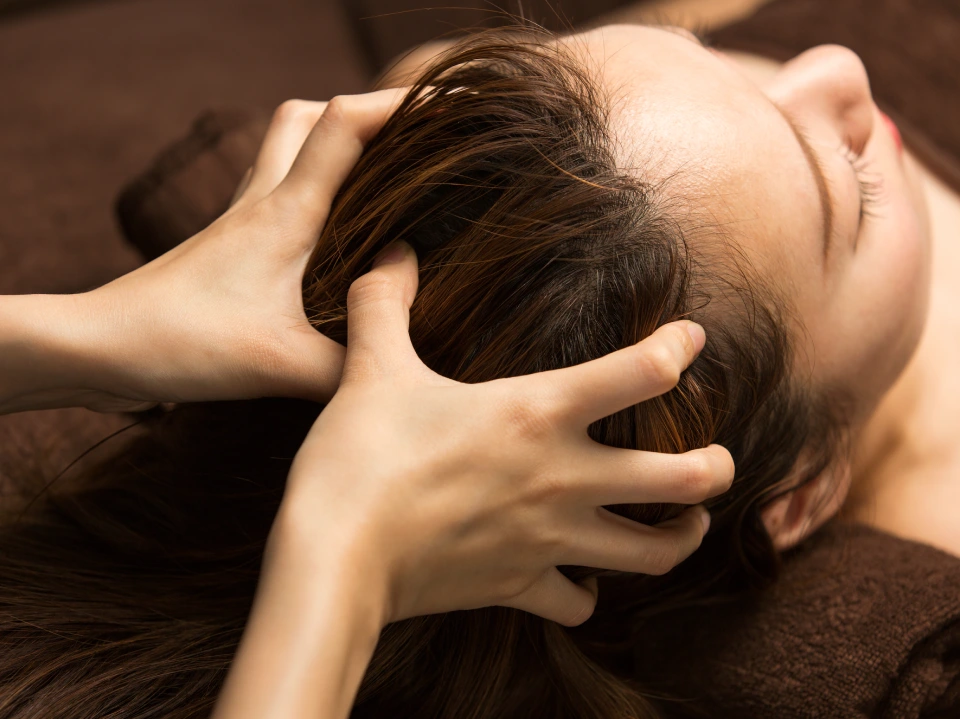 Therapist giving head massage to client